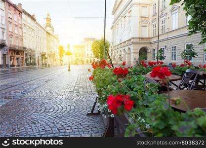 Street cafe terrace with tables and flowers in European city