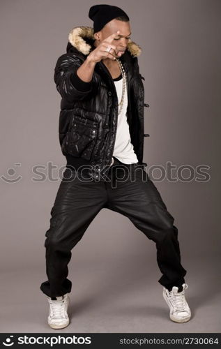 Street dancer showing his dance skills on grey background