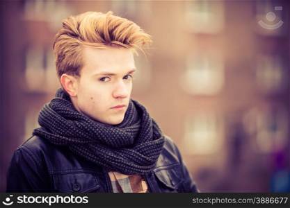 Street fashion. Young fashionable man guy with stylish haircut casual clothes posing outdoor on cityspace background. Aged tone