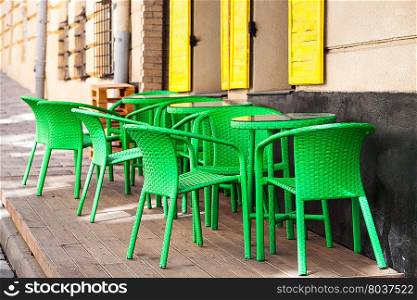Street green cafe tables and chairs in European city