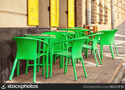 Street green cafe tables and chairs in European city