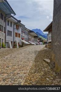 Street in Gruyere village in Fribourg canton by beautiful day, Switzerland. Gruyere village in Fribourg canton, Switzerland
