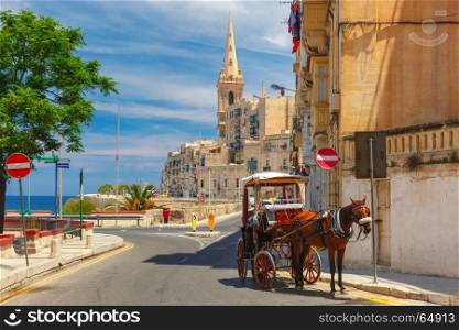 Street in old town of Valletta, Malta. Horse carriage on the street of old town and St. Paul's Anglican Pro-Cathedral in Valletta, Malta