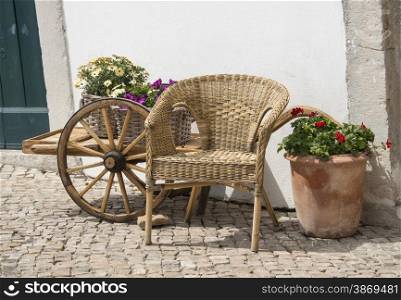 street in village in algarve portugal with flowers and wagon wheel car