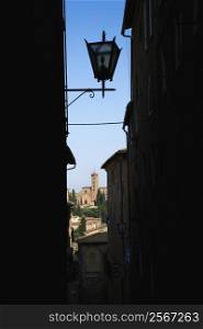 Street lamp and Siena buildings seen through darkened alley.
