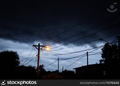 Street light at night with a stormy sky background. Dark mystery scene. Street light at night with a stormy sky background