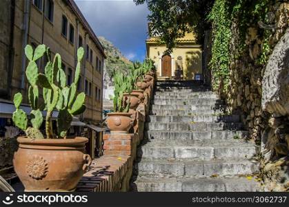 Street of taormina staircase and pots with cactus in the city of taormina