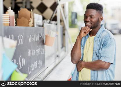 street sale and people concept - male customer looking at billboard at food truck. male customer looking at billboard at food truck