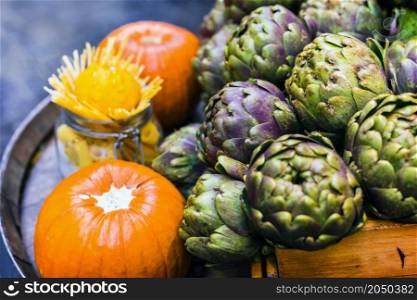 Street still life. Rome, restaurant decoration with fresh seasonal vegetables artichokes and pumpkins