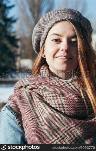 Street style Fashion portrait attractive young woman in trendy winter clothes, smiling, looking at camera. Sunny day, city lifestyle
