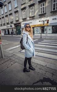 Street Style photo shoot of beautiful fashion blonde woman crossing the street