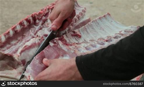 Street vendor cutting fresh pork meat, close-up
