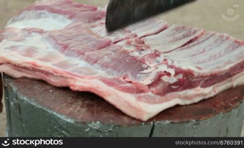 Street vendor cutting fresh pork meat, close-up