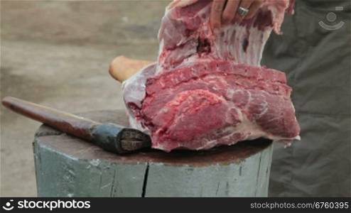 Street vendor cutting fresh pork meat outdoors