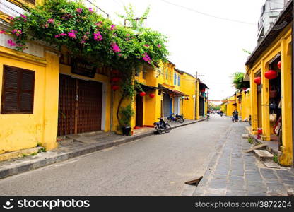 Street vendor with shoulder pole and conical hat in Hoi An Ancient Town, Quang Nam, Vietnam