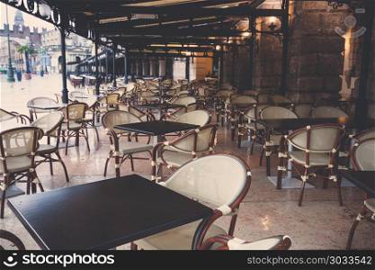Street view of a Cafe terrace with empty tables and chairs, Paris France