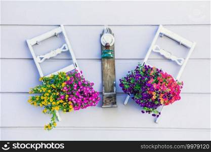 street wall decoration with flowers and wooden chairs.