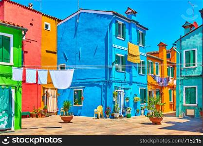 Street with colorful houses and airing clothes in Burano, Venice, Italy