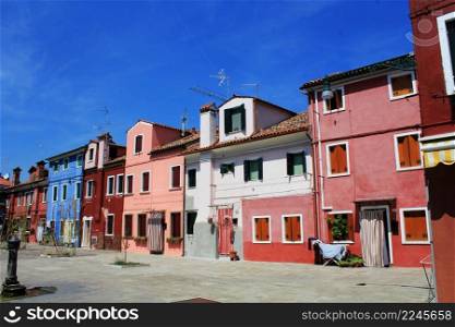 Street with colorful old buildings in Burano island, Venice, Italy.. Street with colorful buildings in Burano island, Venice, Italy.