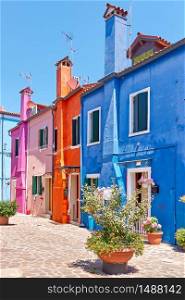 Street with colorful old houses with tall chineys in Burano island in Venice, Italy -- Italian cityscape