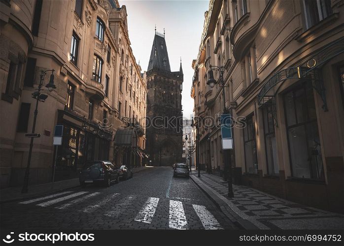 Street with old buildings and an antique tower at the end of it, in the Old City Center of Prague, the capital of the Czech Republic.