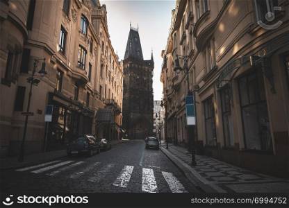 Street with old buildings and an antique tower at the end of it, in the Old City Center of Prague, the capital of the Czech Republic.