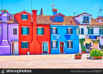 Street with vivid houses in Burano on summer sunny day, Venice, Italy