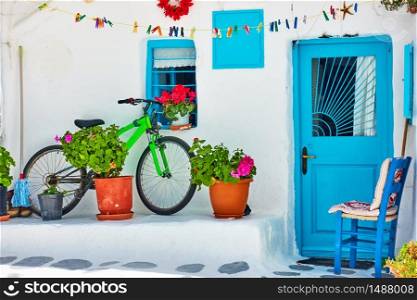 Street with whitewashed house and bicycle near wall in Mykonos island, Greece