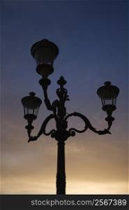 Streetlamp with sunset sky in background in Rome, Italy.