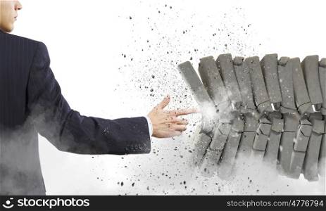 Strength and power. Businessman crushing pile of stones with finger touch