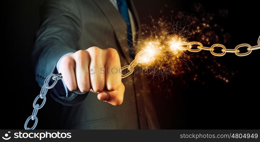 Strength and power. Powerful businessman holding chain in his fist