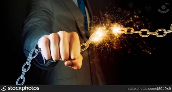Strength and power. Powerful businessman holding chain in his fist