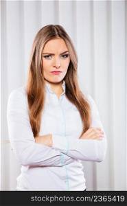 Stress and emotions in business. Professional woman in uniform work in office unhappy and nervous. Angry business woman with crossed arms.