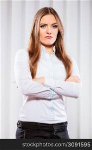 Stress and emotions in business. Professional woman in uniform work in office unhappy and nervous. Angry business woman with crossed arms.