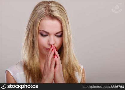 Stress depression negative emotion concept. Thoughtful woman. Attractive blonde girl thinking or praying. Sad face expression on gray copyspace