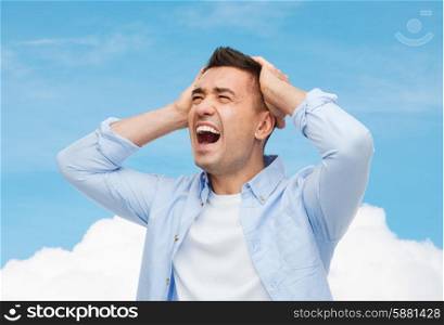 stress, headache, health care and people concept - unhappy man with closed eyes touching his forehead over blue sky and cloud background