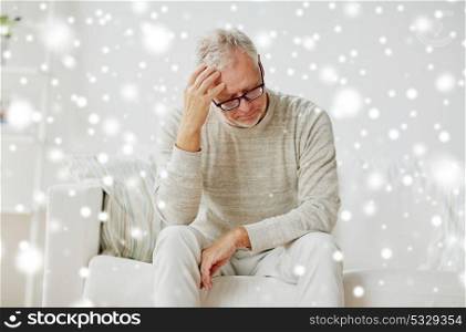 stress, old age and people concept - senior man suffering from headache at home over snow. senior man suffering from headache at home