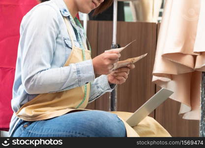 Stressed Asian entrepreneur sitting beside the window because her shop has stopped doing business. Due to financial problems And the economic slowdown. Concept of business crisis