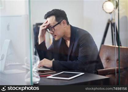 Stressed asian man or businessman at office, failure and headache concept