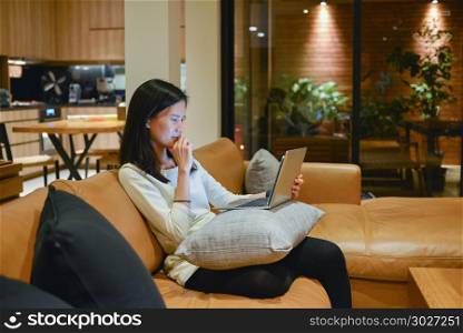 Stressed Asian woman using laptop at night, freelance working la. Stressed Asian woman using laptop at night, freelance working late. Stressed Asian woman using laptop at night, freelance working late