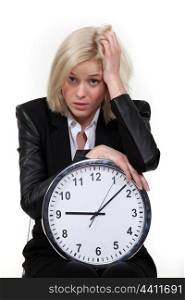 Stressed blond woman with clock