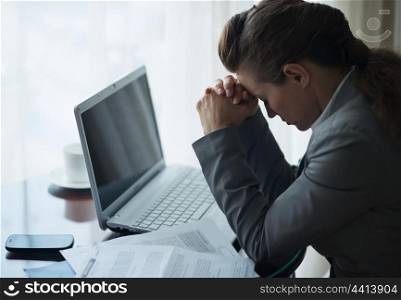 Stressed business woman working sitting at desk in hotel room