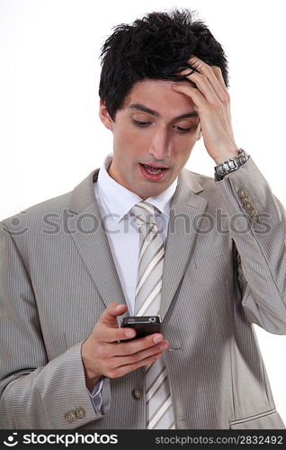 Stressed businessman reading a text message