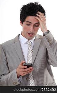 Stressed businessman reading a text message
