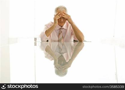 Stressed businessman sitting at table
