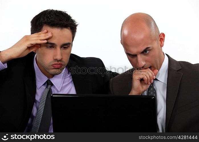 Stressed businessmen looking at laptop screen