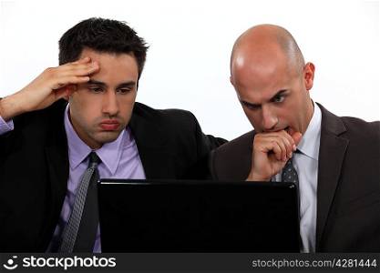Stressed businessmen looking at laptop screen