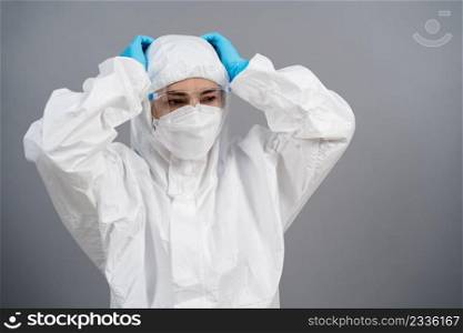 stressed doctor in protective PPE suit during coronavirus covid-19  pandemic