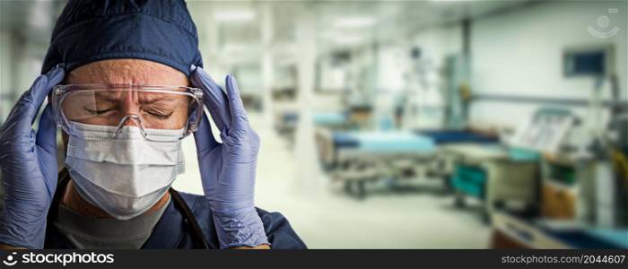 Stressed Doctor or Nurse Wearing Medical Personal Protective Equipment (PPE) Within Hospital.