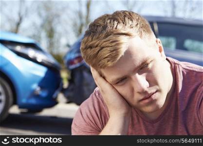 Stressed Driver Sitting At Roadside After Traffic Accident